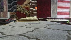 several rugs are lined up on the floor in a room with many different colors and patterns