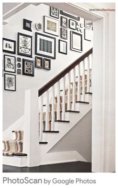 a staircase with pictures on the wall above it