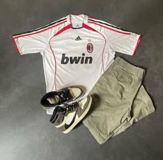 a soccer uniform and shoes are laying on the floor next to each other, including an adidas sneak