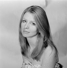 black and white photograph of a woman with long hair wearing a flowered dress posing for the camera