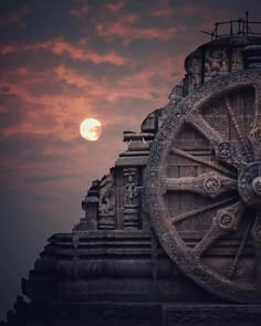 the sun is setting behind a clock tower with intricate carvings on it's face