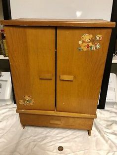 an old wooden armoire with teddy bears on the front and side panels, in good condition