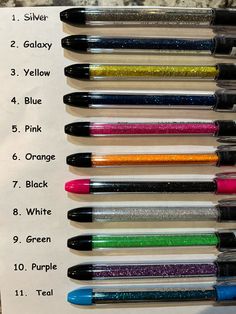 several different colored pens lined up next to each other on top of a piece of paper