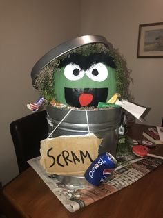 a bucket with a sign that says scram on it sitting on top of a table