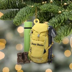 a personalized ornament hanging from a christmas tree next to a pair of hiking boots