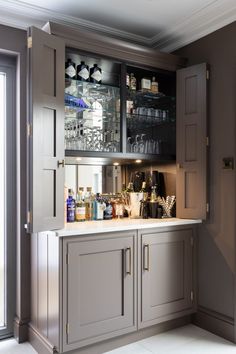 a kitchen with gray cabinets and white counter tops