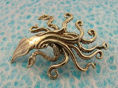 an octopus brooch sits on a blue surface