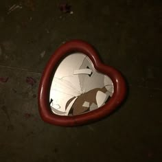 a heart shaped mirror sitting on the ground