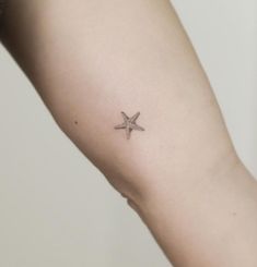 a small starfish tattoo on the arm