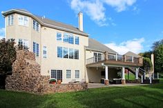 a large house sitting on top of a lush green field