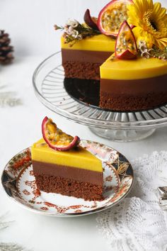 two slices of chocolate cake on plates with flowers and fruit in the middle, one slice missing