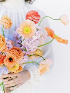 a woman holding a bouquet of flowers in her hands