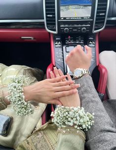 two people holding hands while sitting in a car