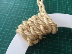 a piece of rope that is on top of a white paper plate and green cutting mat