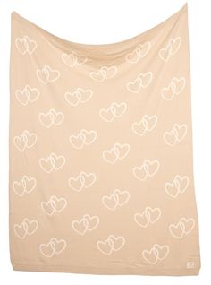 a blanket with hearts on it in beige and white colors, against a white background