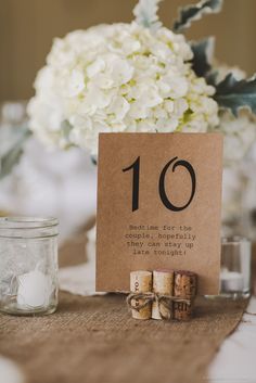 the table numbers are placed on top of wine corks and place cards for guests