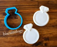 two cookie cutters sitting on top of a wooden table next to each other with the word biscuitlogy written below them