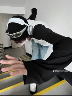 a man in black and white is doing tricks on his skateboard while wearing headphones