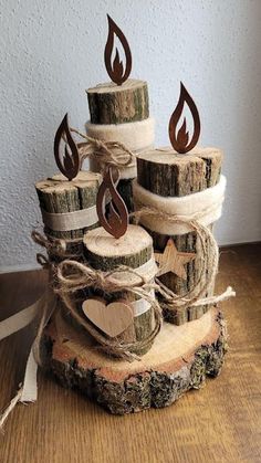 some logs are stacked on top of each other and have candles made out of wood