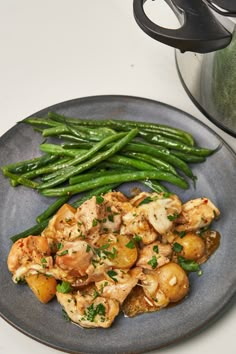 chicken, potatoes and green beans on a plate next to an instant pressure cooker