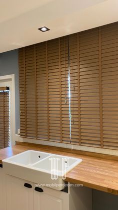 an empty kitchen with wooden blinds in the window