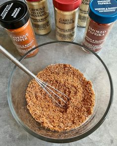 spices and seasonings in a glass bowl with a whisk on the side