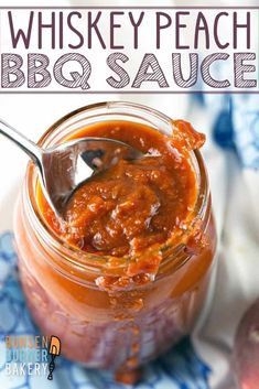 a spoon in a jar filled with bbq sauce on top of a blue and white napkin