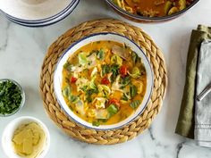 two bowls filled with soup next to other dishes