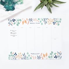 a desk with a plant and calendar on it