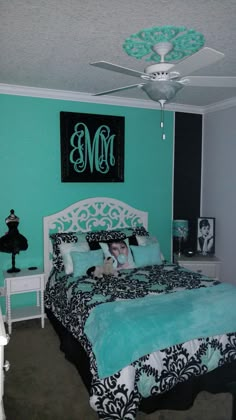 a bedroom with turquoise walls and black and white bedding is pictured in this image