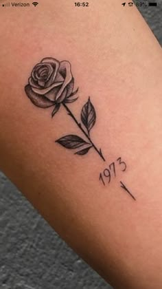 a small rose tattoo on the arm