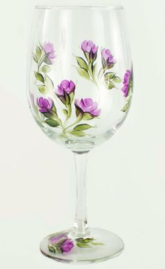 a wine glass with purple flowers painted on it