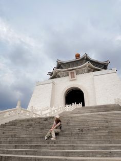 a person sitting on some steps in front of a building