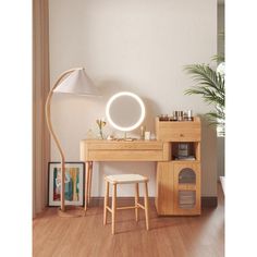 a wooden desk with a mirror, stool and lamp on it in front of a white wall