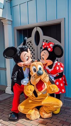 two mickey and minnie mouse statues in front of a door