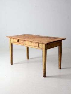 an old wooden table with two drawers on one side and a drawer on the other