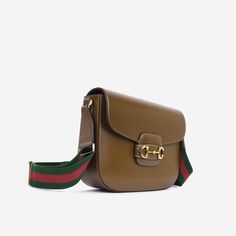 The Horsebit crossbody bag from Gucci goes back to its equestrian roots and the gold hardware is iconic to the brands heritage. Diverse and versatile, this stunning bag is spacious enough for all your essentials, making it a perfect everyday companion. The minimal design makes it suited to almost any outfit - whether it's day or night. SPL Exterior Brown Calfskin Leather Gold-tone hardware Horsebit hardware Red / Green Strap Leather slot closure Adjustable shoulder strap Unused condition - loose thread on strap Interior Beige microfibre interior Zip pocket Gucci embossed leather logo tag Excellent condition Sold with box, dustbag and strap SPL Height 20cm Width 25.5cm Depth 9cm Luxury Brown Bag With Horsebit Detail, Designer Brown Shoulder Bag With Horsebit Detail, Brown Travel Bags With Horsebit Detail, Brown Crossbody Bag With Horsebit Detail, High-end Leather Bag With Horsebit Detail, Handbag Backpack, Minimal Design, Exclusive Bag, Embossed Leather