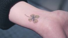 a small four leaf clover tattoo on the left inner arm and wrist, is shown