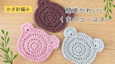 three crocheted items on a wooden surface with japanese characters in the back ground