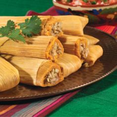 several tamales on a plate with garnishes