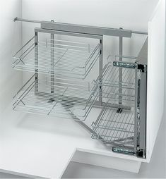 an open cabinet with metal shelves and wire baskets on the bottom, in a white room