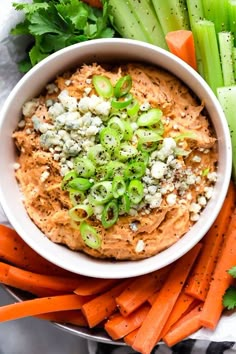 carrots, celery and other vegetables on a plate with dip in the middle