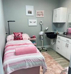 a bed room with a neatly made bed next to a sink and a mirror on the wall