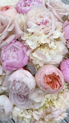 a bouquet of pink and white flowers sitting on top of a wooden table