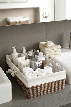 a bathroom sink with soap, lotion and other items in the basket next to it