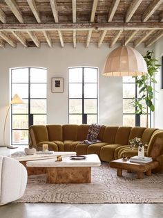 a living room filled with lots of furniture next to tall windows and large windows on the wall