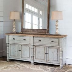 an old dresser with a large mirror on top of it and two lamps next to it