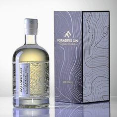 a bottle of cologne sitting next to a box on a white surface with an abstract pattern