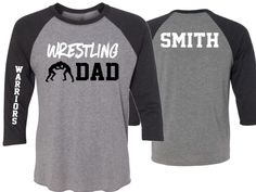 two grey and black shirts with wrestling dad printed on them