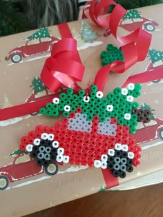 a christmas present wrapped in brown paper with red ribbon and green tree decorations on top